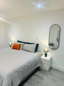 um quarto com uma cama com um espelho na parede em Hemel Apartments- City Zen em Hemel Hempstead