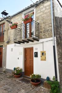 a building with a wooden door and a balcony at Casa Vacanze La Dimora di Santa Barbara in Petralia Soprana