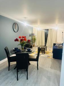 uma sala de estar com uma mesa e cadeiras e um sofá em Hemel Apartments- City Zen em Hemel Hempstead