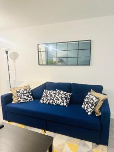 um sofá azul com almofadas numa sala de estar em Hemel Apartments- City Zen em Hemel Hempstead