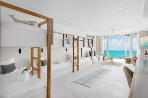 a room with two bunk beds and the ocean at La Mer South, Luxury Oceanfront on Sapodilla Bay in Providenciales