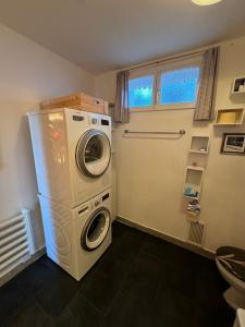 eine Waschküche mit einer Waschmaschine und einem Fenster in der Unterkunft Flumserberg in Flumserberg