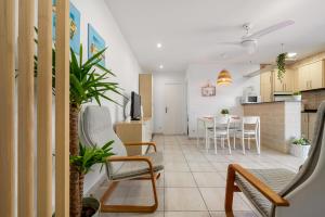 ein Wohnzimmer mit Stühlen und eine Küche in der Unterkunft Hauzify I Apartament Llevant in Santa Susanna