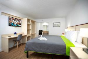 a hotel room with a large bed and a desk at Weekly Inn 