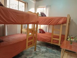 a room with two bunk beds and a table at Linda Casa de campo frente a Laguna de Pacucha in Pacucha