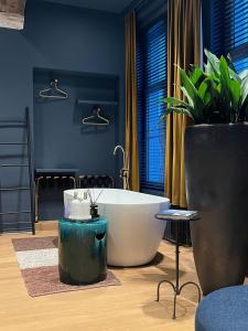 een badkamer met een bad en een potplant bij Maison Brunon in Brugge