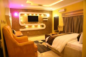 a hotel room with a bed and a tv at Portland Resort Hotel in Port Harcourt