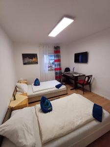 Habitación con 3 camas y escritorio con ordenador. en APARTMENTS / WOHNUNG IN HAIBACH, en Haibach