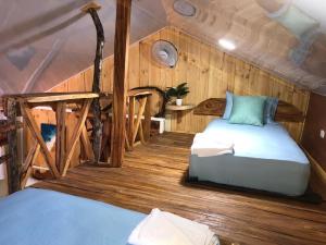 una camera con due letti in una stanza con pareti in legno di Rustic House 2 a Punta Rucia