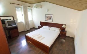 Un dormitorio con una cama y un televisor. en Vila 57 HOTEL, en Tirana