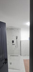 a shower in a bathroom with a white wall at Cabana Pietrele Șoimului in Cavnic