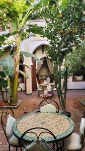 a patio with a table and chairs and trees at Riad Tidar by Phoenix in Marrakesh