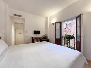 a bedroom with a large white bed and a window at Al Duomo di Cagliari in Cagliari