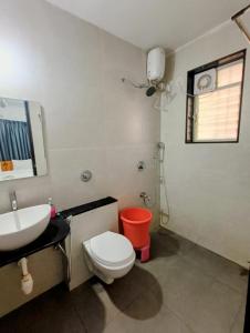 uma casa de banho com um WC branco e um lavatório. em Ornate Service Apartments em Pune