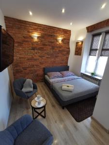 1 dormitorio con cama y pared de ladrillo en NADWIŚLAŃSKI APARTAMENT Kalwaryjska en Cracovia