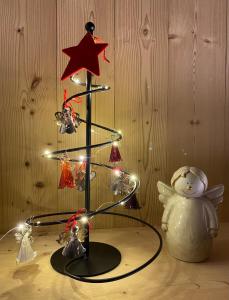 un pequeño árbol de Navidad con luces en una mesa en La Grange de Soulalex, en Orsières
