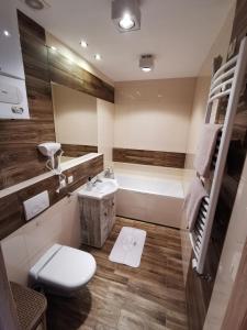 y baño con aseo, lavabo y bañera. en NADWIŚLAŃSKI APARTAMENT Kalwaryjska, en Cracovia