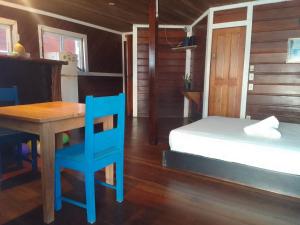 ボカス・タウンにあるCasa elba sobre el marのベッドルーム(テーブル、ベッド、青い椅子付)