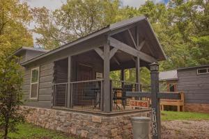 une grande terrasse couverte sur une petite maison dans l'établissement Meg Cabin Tiny Rustic Comfort On Lookout Mtn, à Chattanooga