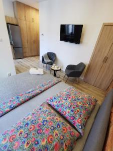 Habitación de hotel con 2 camas y mantas coloridas en NADWIŚLAŃSKI APARTAMENT Kalwaryjska en Cracovia
