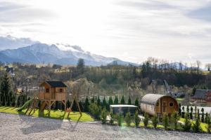 a playground with a tree house and a swing at Osada LUX-HOUSE & SAUNA in Zakopane