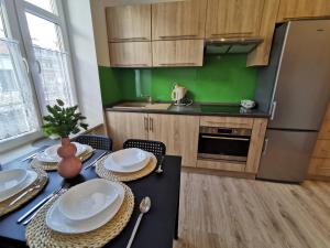 una cocina con una mesa con platos. en NADWIŚLAŃSKI APARTAMENT Kalwaryjska en Cracovia