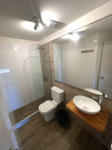 La salle de bains est pourvue de toilettes, d'un lavabo et d'un miroir. dans l'établissement Vintage Home en Pocitos, à Montevideo