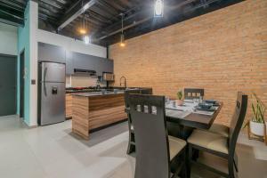 a kitchen with a table and a brick wall at Depa Industrial Moderno #1 in Durango
