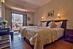 a bedroom with a large bed and a balcony at Hotel Doupiani House in Kalabaka