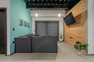 ein Wohnzimmer mit Sofa und Ziegelwand in der Unterkunft Depa Industrial Moderno #1 in Durango