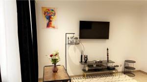 salon ze stołem i telewizorem na ścianie w obiekcie Calme, agréable et fonctionnel w Brukseli