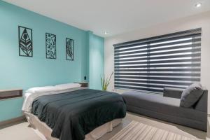 sypialnia z niebieskimi ścianami, łóżkiem i oknem w obiekcie Depa Industrial Moderno #1 w mieście Durango