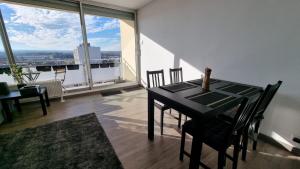 a dining room with a table and chairs and a large window at Dreamy Suite for Sunsetlovers in Saint-Louis