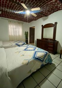 Villas de Morenos في Buenavista: غرفة نوم بسرير ومروحة سقف