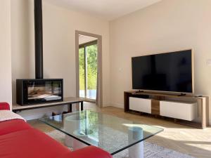 a living room with a flat screen tv and a red couch at Villa Jacuzzi Calme & Elegance - Prox Mer - Clim & Cheminée - Parking in Cagnes-sur-Mer