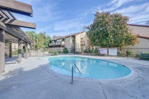 a swimming pool in front of a building at Cozy Fresno Condo with Balcony and Pool Access in Fresno