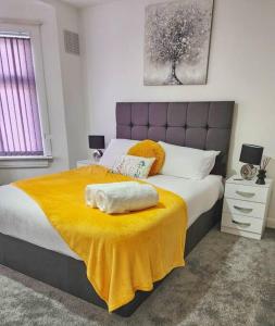 a bedroom with a large bed with a yellow blanket at 3 Bed Home - Sleeps up to 5 - Coventry - Contractors, Families and Relocators in Coventry