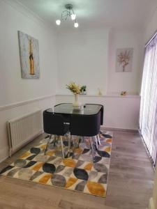 a dining room with a table and chairs on a rug at 3 Bed Home - Sleeps up to 5 - Coventry - Contractors, Families and Relocators in Coventry