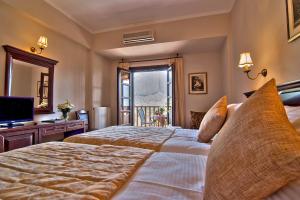 a large bedroom with two beds and a television at Hotel Doupiani House in Kalabaka