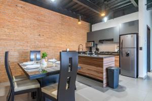 a kitchen with a dining table and a refrigerator at Depa Industrial Moderno y Comodo in Durango