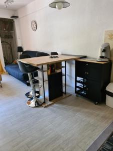 a desk in a living room with a table and chairs at Agréable appartement-Résidence Le Panoramic in Les Angles