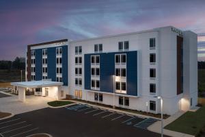 a large white building with a parking lot at SpringHill Suites by Marriott Fayetteville I-95 in Fayetteville