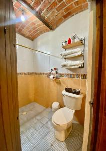 a bathroom with a toilet and towels in it at Villas de Morenos in Buenavista