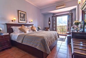 a bedroom with a bed and a balcony at Hotel Doupiani House in Kalabaka