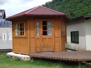 Cabaña con puerta de madera y terraza en Ayu no Sato Park Campsite - Vacation STAY 42154v en Shōbara