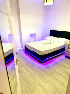 1 dormitorio con 1 cama con luces moradas en el suelo en Flat The Shard, en Londres