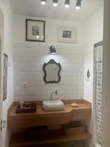 uma casa de banho com um lavatório e um espelho na parede em apartamento reformado e bem localizado no Humaitá no Rio de Janeiro