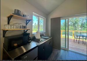 a kitchen with a counter and a deck with a table at Deluxe Cabin 5 - Rogue River Resort in Grants Pass