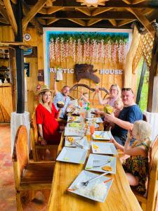 a group of people sitting around a long wooden table at Rustic House 2 in Punta Rucia