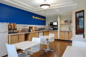 une cuisine avec des tables blanches et des chaises blanches dans l'établissement Days Inn by Wyndham Whitecourt, à Whitecourt